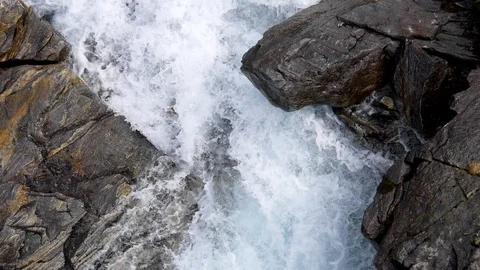 Foamy water flowing violently between rocks in a mountain stream in Norway Video stock 112595751
