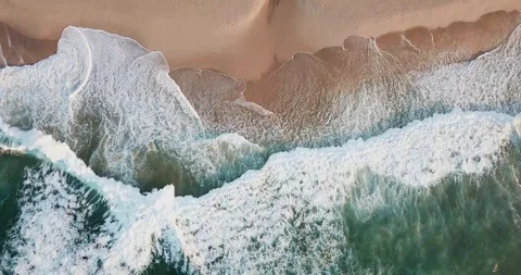 Foamy wave rolls on the sandy shore of the ocean from a bird's-eye view Stock Footage 130168503