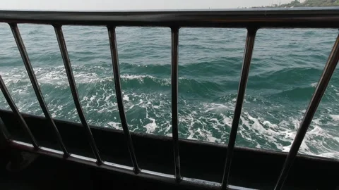Foamy waves framed by ferry railing, close sea view in motion Stock Footage 320029530