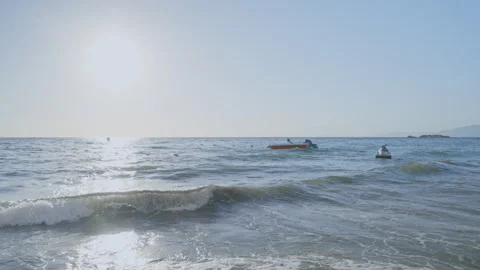 Foamy waves of medium intensity wash seashore rocking motor boats on beach Stock-Footage 253655992