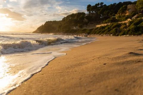 Foamy waves rolling on sand Stock Photos