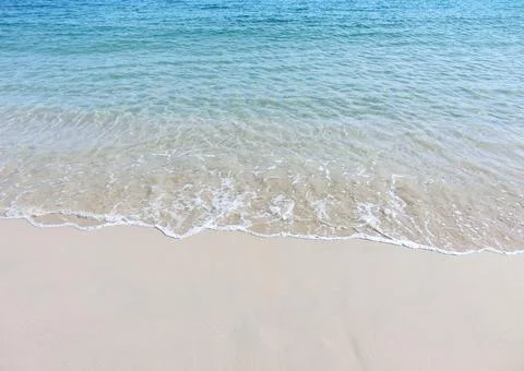 Foamy waves on a sandy beach Stock Photos