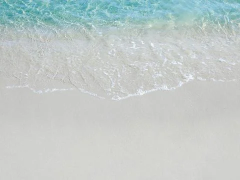Foamy waves on a sandy beach Stock Photos