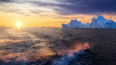 Foamy waves at sea in the rays of the setting sun Stock Photos