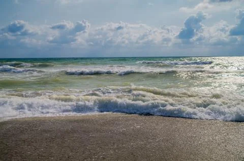Foamy waves on the shore. Stock Photos