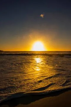 Foamy waves at sunset Stock Photos