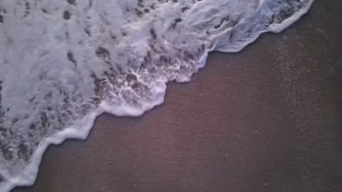 Foamy Waves Wash Up On Sand, Closeup with Drone Stock Footage 169671949