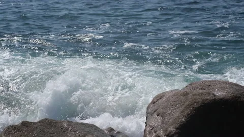 Foamy white waves splashing over rocks at beach in slow motion. Follow shot. 動画素材 151874838