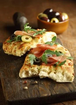Focaccia bread with ham, rocket and olives Stock Photos