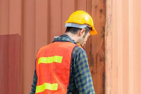 Foctory worker man in hard hat and safety vest at containers cargo Photos