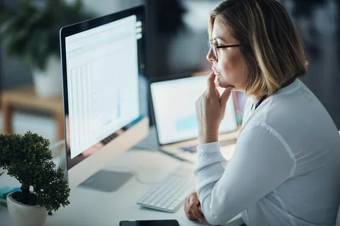 Focus and dedication got her far. a businesswoman using a computer during a late Stockfoto's