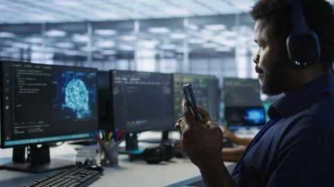 Focus on artificial intelligence server farm employee using mobile phone Foto stock