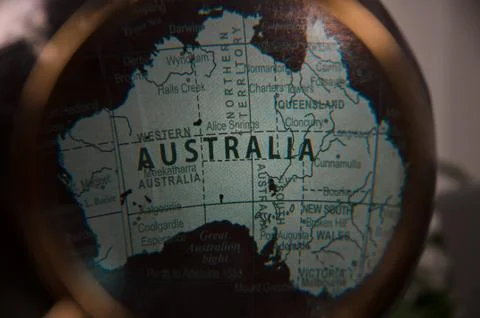 Focus on Australia world map under magnifying glass Fotos Stock