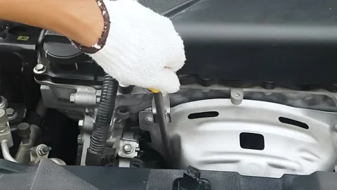 Focus, auto mechanic pulling, yellow dipstick. Stock Footage 157741415