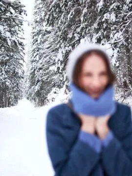 Focus on the background, blur objects. brunette walks through the winter forest Stock Photos