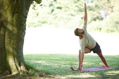 Focus on being a triangle. Full length shot of a handsome mature man doing yoga Stock Photos