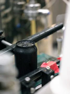 Focus on a can of craft beer packaged in a canning plant Stock Photos