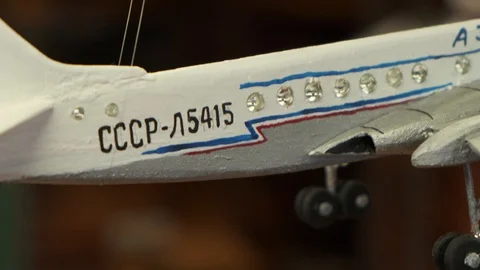 Focus changes from hanging airplane model to man at table Stock Footage 127837577