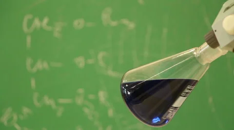 Focus changes from rotating blue flask  close-up to chemical formulas Stock Footage 53542989