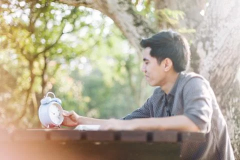 Focus on clock, Young man looking at clock while studying Stock Photos