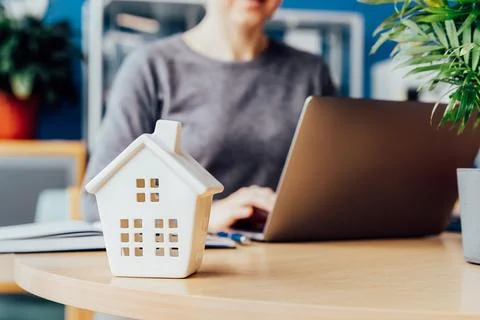 Focus on closeup house model miniature on realtor table, businesswoman real Stock Photos