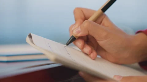 Focus on detailed hand movements while taking notes during study. Close Stock Footage 337722436