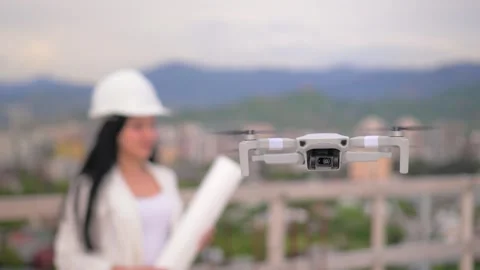 Focus on drone flying and hovering in air, against background of woman in helmet 库存影片 240342168
