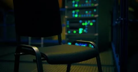 Focus on an empty chair in a dimly lit server room filled with lights Stock Illustration