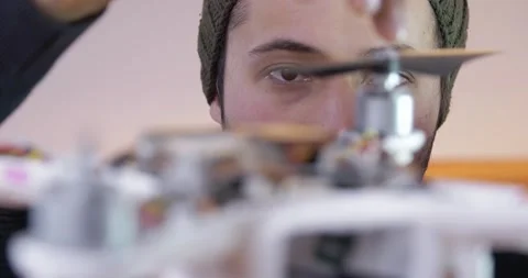 Focus on the eyes of the person who assembles the robot Assembly drone Stock Footage 147411191