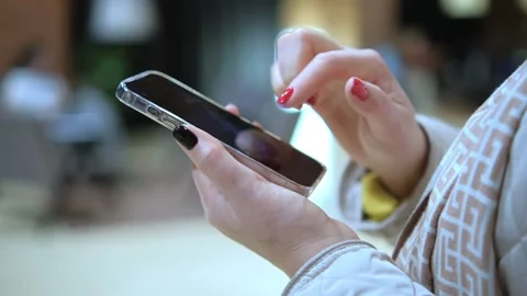 Focus on Female Hand Using Smartphone. Woman Holding Mobile Phone, Posting Stock Footage 256671410