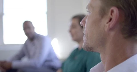 Focus on foreground man as mixed race friends talk in background 4K Stock Footage 80296232