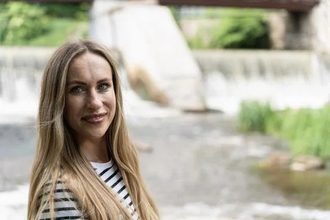 Focus on foreground on a smiling long-haired woman against the background of the Stock Photos