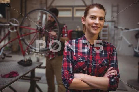 Focus On Foreground Of Woman Mechanic With Arms Crossed
