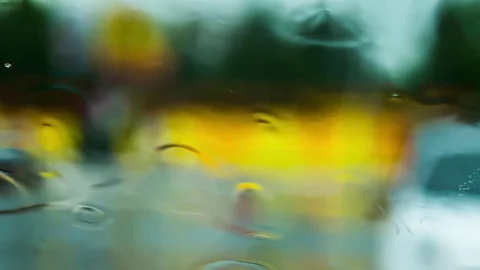 Focus on the glass, the background is blurred, it's raining, the person's figure Stock Footage 74543151
