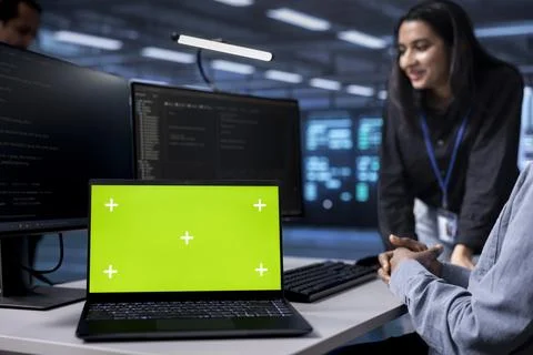 Focus on green screen notebook used by data center admins in blurry background Foto stock