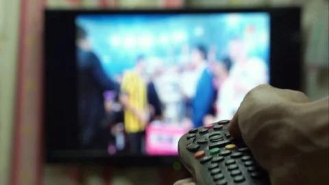 Focus on hand is pinch button on television remote control Stock Footage 91897995