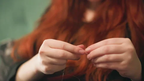 Focus on hands handling tiny beaded pendulum with care. Macro portrait capturing 動画素材 346561544