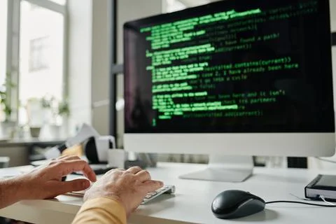 Focus on hands of mature programmer typing on keyboard Stock Photos