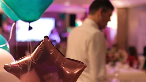 Focus on helium balloon during wedding party with blurred people in background Stock Footage