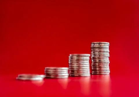 Focus on the highest coin stacks as graph chart steps isolated on red backg.. Stock Photos