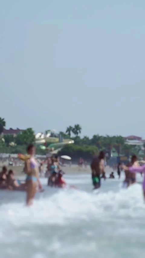 Focus on horizon background, summer beach scene with people enjoying ocean waves Stock Footage 330519137