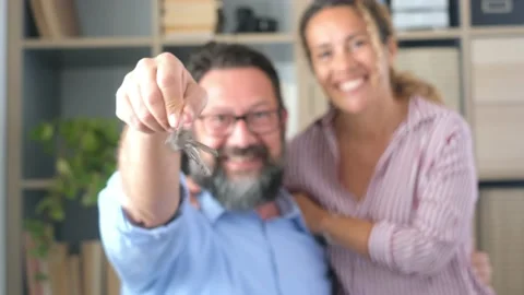 Focus on keys, held by excited young spouses homeowners. Happy married family co Vídeo Stock 151322083