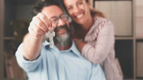 Focus on keys, held by excited young spouses homeowners. Happy married family co Stock-Footage 151322119