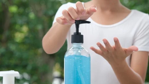 Focus at kid hands using alcohol gel to clean Stock Footage 129553786