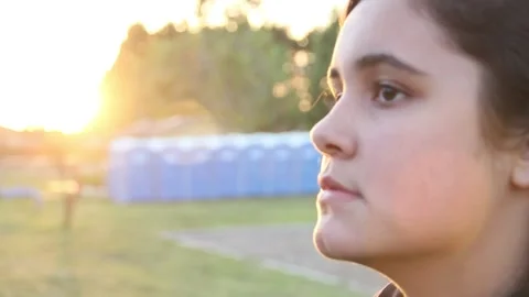 Focus in on kid's face with sun setting in background Stock Footage 154991941