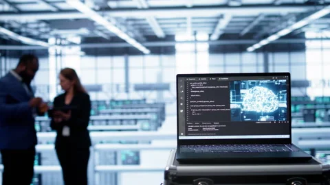 Focus on laptop in data center with AI brain used by engineers in background Stock Footage 277647005