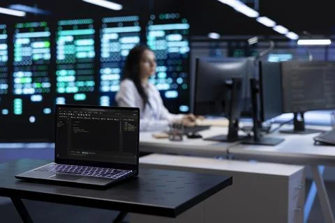 Focus on laptop in front of data center employees Stock Photos
