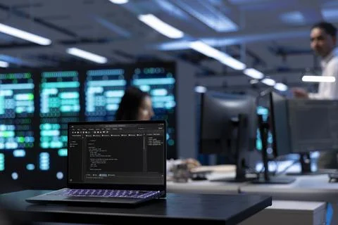 Focus on laptop used by IT developer in server room to find network issues Stock Photos