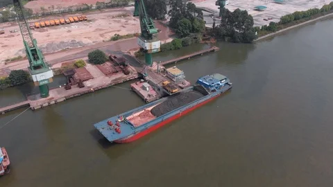 The focus is a large cargo ship moored at the port. Stock Footage 118032015