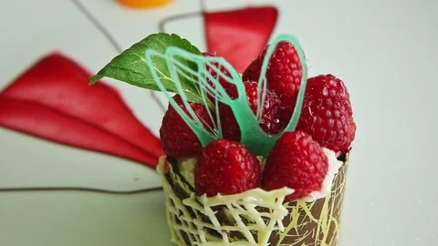 Focus in macro at finely decorated raspberry cream dessert Stock Footage 123782812